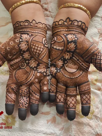 The bride's name, 'Vivanah', is elegantly written inside a circular frame on her palm, surrounded by beautiful lotus and paisley patterns.