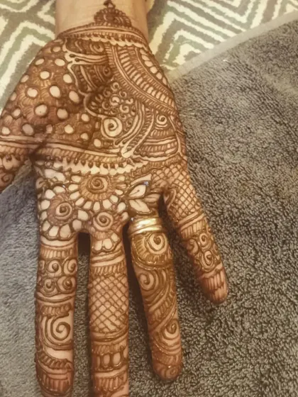 This palm design features a mix of dots, swirls, and floral patterns, showing the variety within Indian mehendi art.