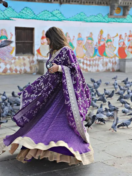 This purple bandhani-style lehenga is perfect for a pre-wedding shoot or event. The flowing fabric and rich color look stunning against any backdrop.
