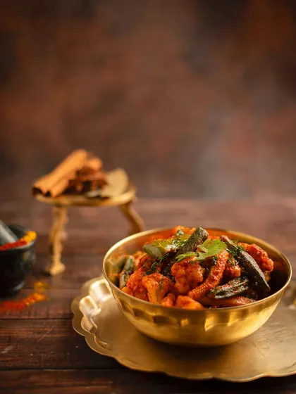 A collection showing the variety of our curries, from the preparation of Chicken Tikka Masala and smoky Kadai Paneer to finished bowls of Palak Paneer, Jeera Aloo, and Chicken Kadai. Each dish is prepared fresh and served hot.