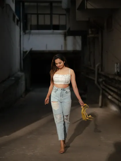 A walking shot in an urban alleyway. The leading lines of the corridor and the focused light create a cinematic feel, as if capturing a moment in a story.