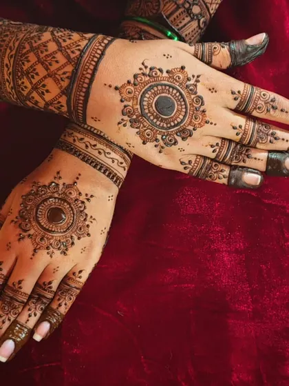 A classic mandala design on the back of the hand. The central circle is surrounded by layers of intricate patterns, creating a beautiful focal point.