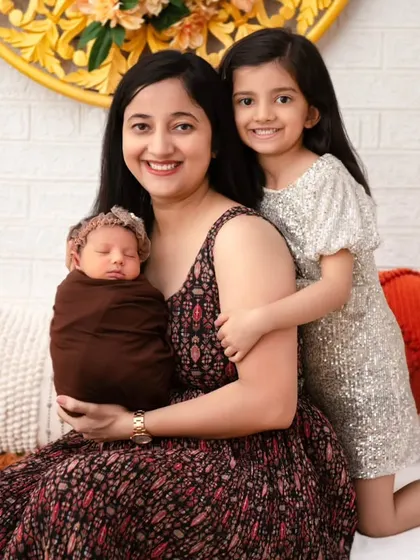 A mother and her two children. This heartwarming photo captures the loving embrace of a mother and her eldest daughter as they welcome the newest, tiniest member of their family.