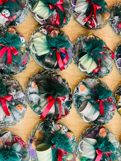 A closer view of the small, round Christmas hampers, showing the mugs and other small gifts inside.