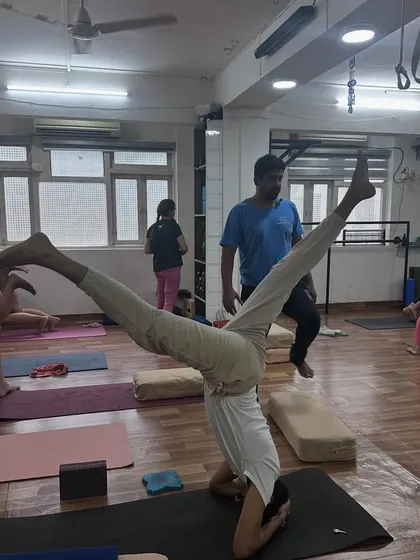 This practitioner holds a wide-legged variation in his headstand, showcasing advanced control and flexibility.