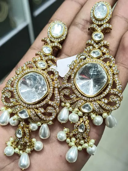 A pair of grand, oversized earrings with large Polki stones and American diamonds, finished with pearl drops. These are perfect for a bride or for making a bold statement.