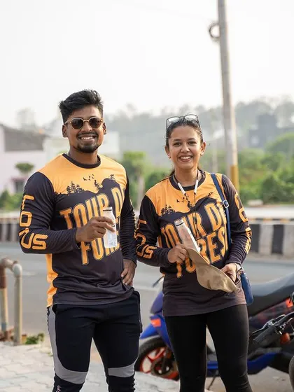 Two participants of the Tour de Forest pose in their custom event jerseys, enjoying a break during the ride.