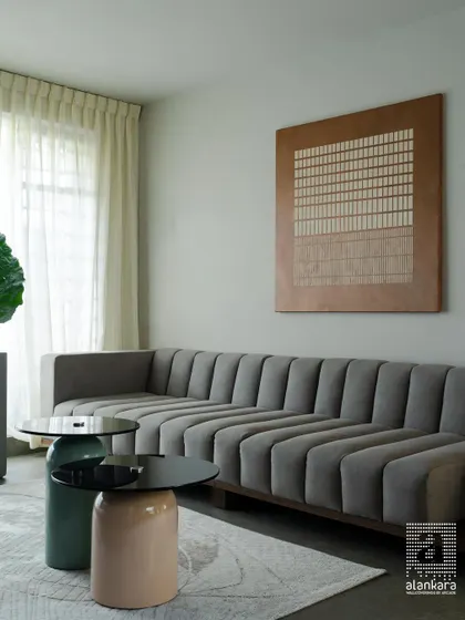 The centerpiece of this room is a custom-designed channel-tufted sofa, offering a contemporary yet comfortable seating solution. Paired with artistic coffee tables and sheer curtains, the space feels open, luxurious, and inviting.