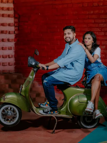 A fun and quirky shot of a couple on a vintage scooter.
