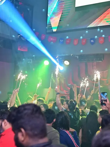 The view from the dance floor at Tipsy Bull. A sea of people, sparklers held high, and a blue spotlight cutting through the haze. Pure magic.