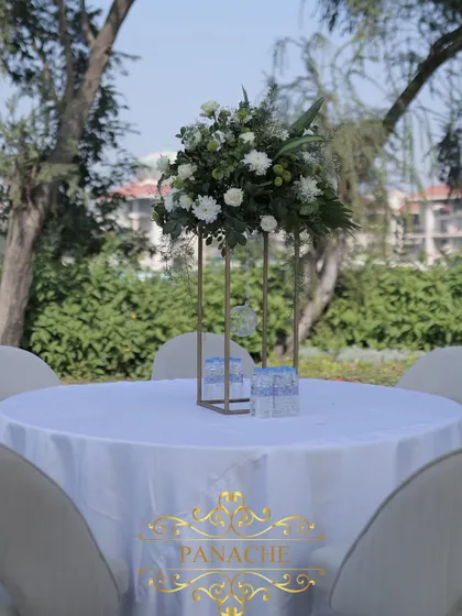 A simple and elegant centerpiece of white flowers on a guest table.