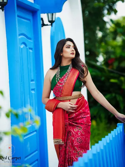 Sonal looking stunning against a Santorini-inspired backdrop. The red of the saree and the blue of the door create a beautiful contrast.