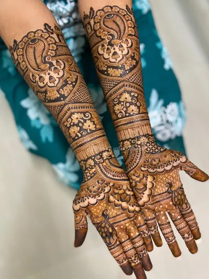 A stunning bridal design with large, bold peacocks on the arms. The intricate feather details and surrounding floral patterns make this a true work of art.