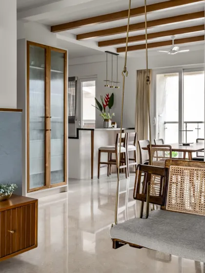 The dining space in 'Malhar' is adorned with a full-height crockery unit with fluted glass doors. This piece provides ample storage while adding a touch of elegance and visual lightness to the room.