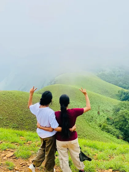 Friends for life, made on the trail. Two trekkers celebrating their climb with a view of the beautiful Netravati landscape.