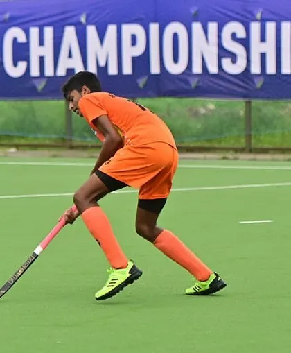 A player dribbling the ball during the West Zone Championship. Our training focuses on developing strong stick skills and field awareness.