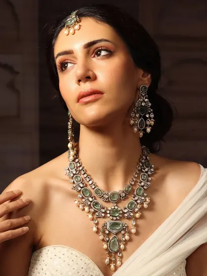 From our Emrosia collection, this layered emerald and polki set with a matching maang tikka is designed for the bride who desires a look of regal elegance.