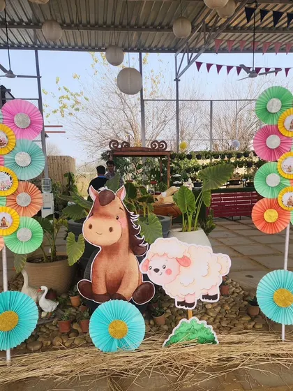 Decorative elements at the farm party, featuring colorful paper pinwheels and cutouts of a horse and sheep. These were used to brighten up the entrance and other areas of the venue.