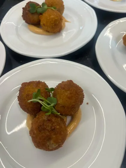 The appetizer course: Mushroom and Truffle Arancini, carefully plated on a swirl of sauce and garnished with microgreens. This is how we bring restaurant-quality plating to your home.