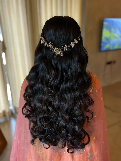 The final look of the curly half-updo, showing the volume and definition of the curls. It's a romantic and glamorous choice.