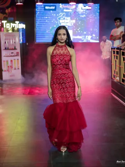 The full runway look of the red gown, showing how the tiered tulle bottom moves as the model walks.