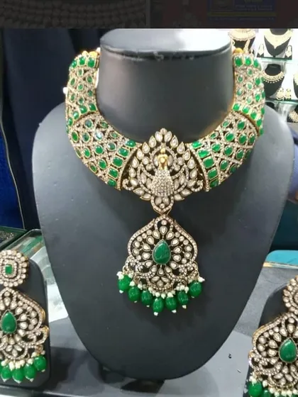 This heavy bridal necklace set features a unique peacock pendant design, surrounded by rich green stones and detailed kundan work. It comes with matching oversized earrings to create a truly grand statement.