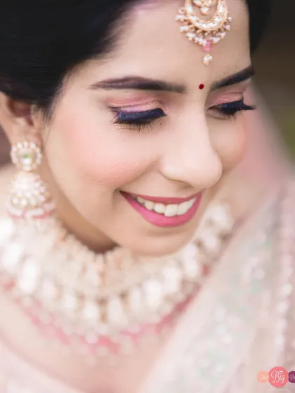 A happy, smiling close-up of the bride, Ratika, showcasing her beautiful pink-toned makeup.