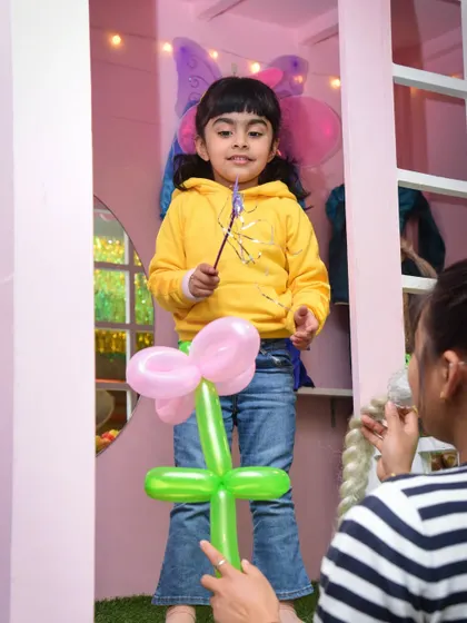 A little fairy with a magic wand receives a flower balloon. It's these small, personal interactions that make our events special.