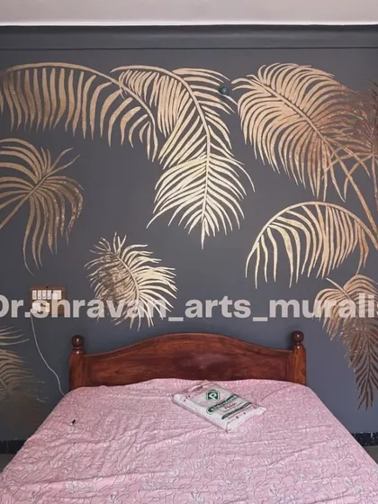 The classic look of gold foil can elevate any space. Here, large tropical palm fronds in gold foil are set against a dark grey wall, creating a dramatic and sophisticated bedroom feature.