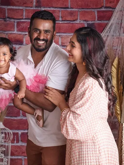 A simple, candid family portrait that is full of warmth and connection. Against a rustic brick backdrop, this moment between parents and their little one shows that sometimes, the most powerful photos are the most natural ones.