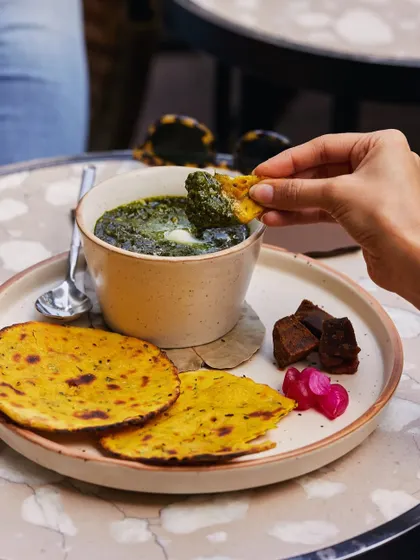 A classic winter pairing. Makki di roti, a rustic corn flatbread, served with sarson ka saag, a dollop of white butter, and jaggery.
