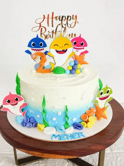 Doo doo doo doo doo doo. A fun and colorful Baby Shark cake for Meher's 2nd birthday, featuring the whole shark family swimming in a whipped cream ocean.