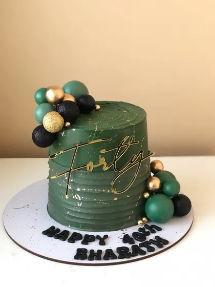 A handsome cake for a 40th birthday, with a textured olive green buttercream and a black and gold color scheme.