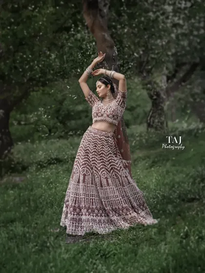 A graceful and artistic bridal portrait in a woodland setting. The bride's pose is elegant and expressive, and the soft, natural light filters through the trees beautifully.