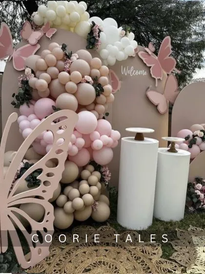 Your celebration can be as delicate and beautiful as a butterfly's wing. This outdoor setup features intricate, large-scale butterfly cutouts, a soft pink and neutral balloon arrangement, and floral accents for a truly enchanting experience.