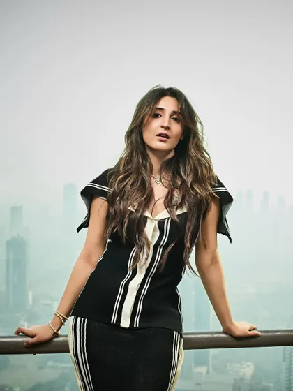 A powerful stance overlooking the city. This shot shows the full black and white striped co-ord set, a perfect example of modern, graphic dressing.