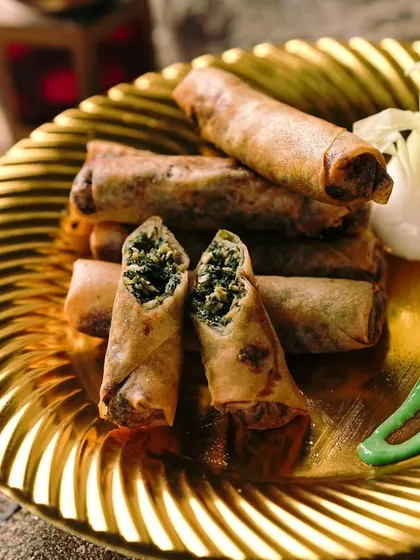 These Spinach Chicken Cigars are rolled tight and spiced right. The crispy shell gives way to a savory filling of chicken and spinach, served with a vibrant green chutney.