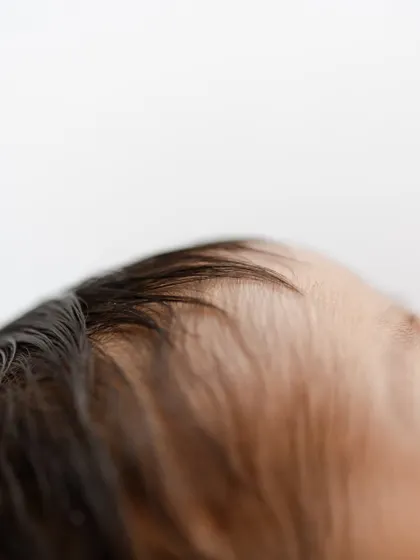 The soft, fine hair on a newborn's head. These are the fleeting details that change so quickly.