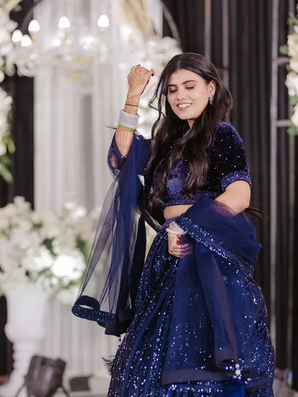 A beautiful shot of a bride mid-twirl, her blue lehenga and joyful expression capturing the magic of her solo dance.
