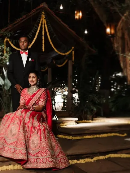 A stunning reception portrait of a couple in a beautifully decorated outdoor setting. The warm lighting and elegant decor create a magical and romantic scene.