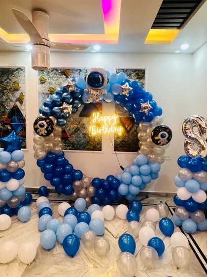 The full setup of the circular space-themed balloon arch at home, including balloon columns and a large foil number '8'.