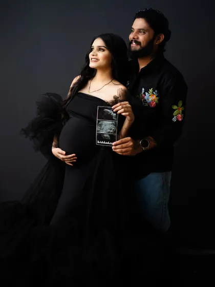 A glimpse of the future. The couple holds up their baby's sonogram, a perfect way to announce their excitement in a modern and stylish maternity shoot.