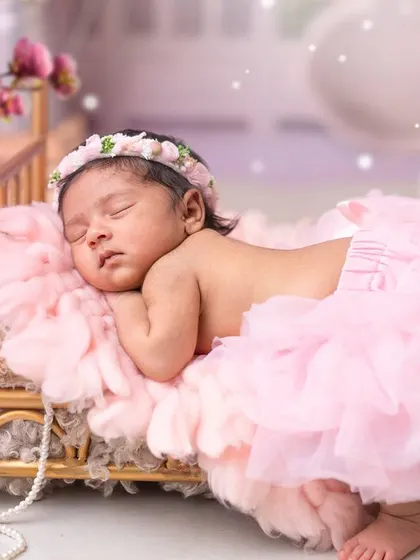 A beautiful newborn girl sleeping peacefully in a pink tutu, embodying the magic of a butterfly or fairy theme.