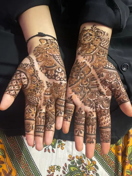 A classic Eid henna design with full palm coverage. It combines traditional Indian mehendi elements like paisleys, dots, and fine lines.