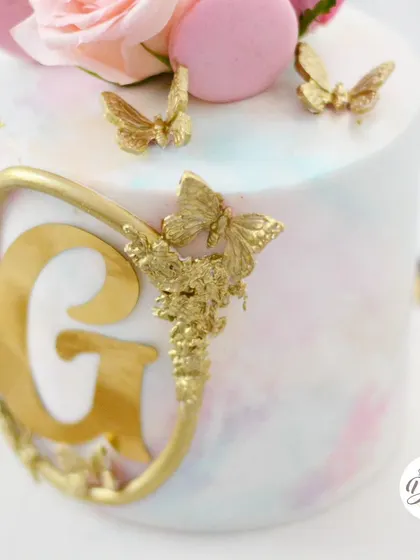 A detailed shot of the intricate gold butterfly and monogram work.
