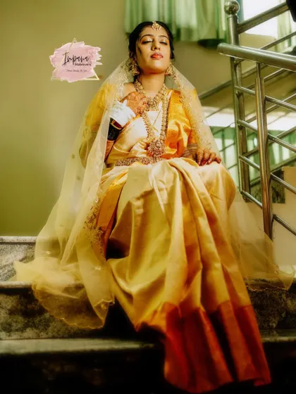 A regal portrait of a bride on her wedding day. The sheer veil, intricate gold jewellery, and flawless makeup come together to create a truly majestic South Indian bridal look.