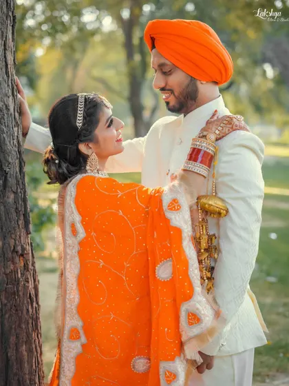 A romantic pose against a tree, with the couple lost in each other's eyes. The natural park setting provides a soft and beautiful backdrop.