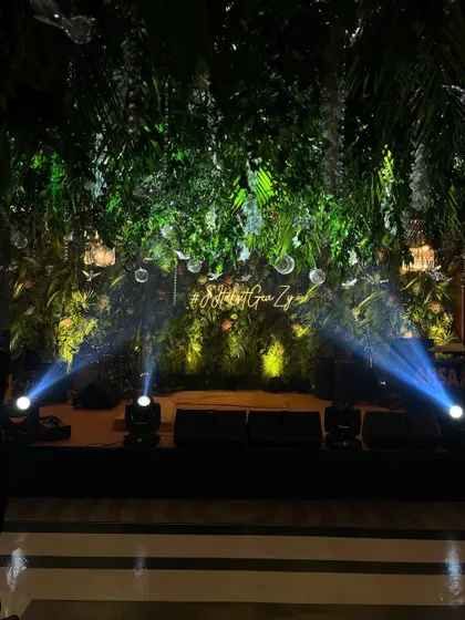 The stage for our jungle themed party, featuring a custom neon sign and spotlights. The dense green backdrop and dramatic lighting created an exciting focal point for the evening's entertainment.