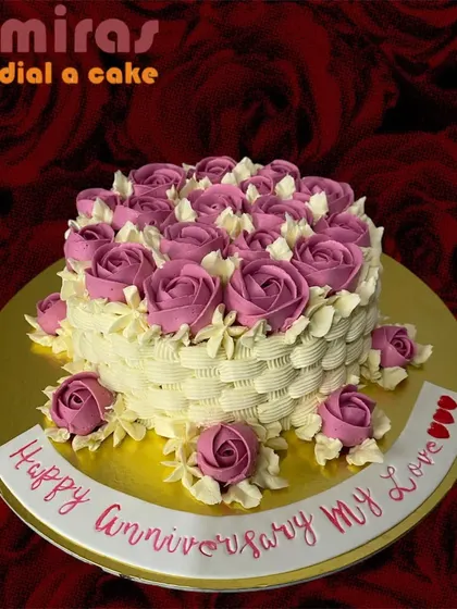 A beautiful anniversary cake designed to look like a basket of flowers. The sides are piped to create a basket-weave texture, overflowing with lovely pink buttercream roses.
