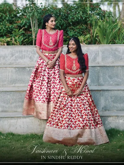 Our clients Vaishnavi and Minal look stunning in their coordinated red and pink lehengas, a perfect example of friendship goals.